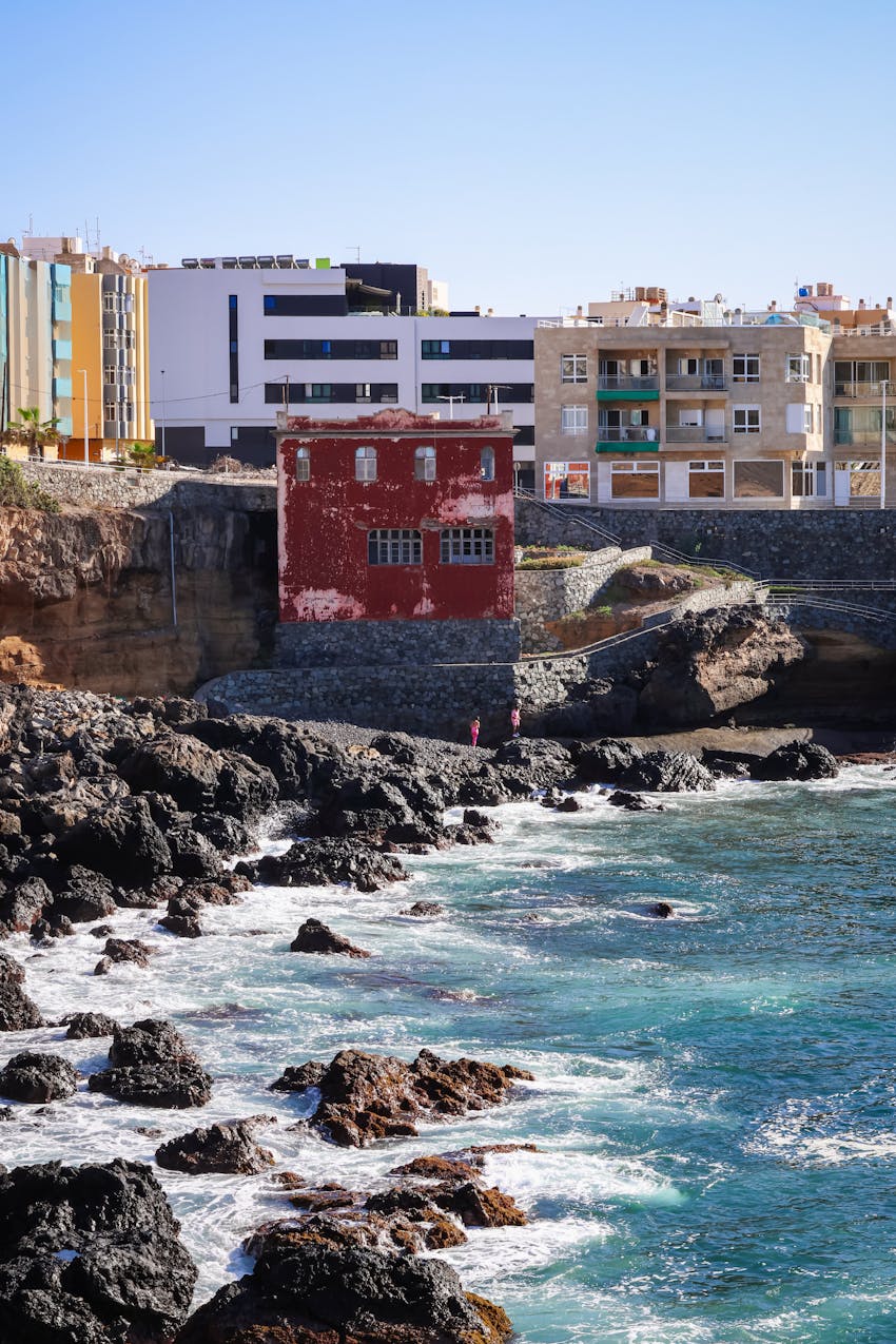 Charming coastal scene in Las Palmas, showcasing rugged cliffs and coastal architecture.