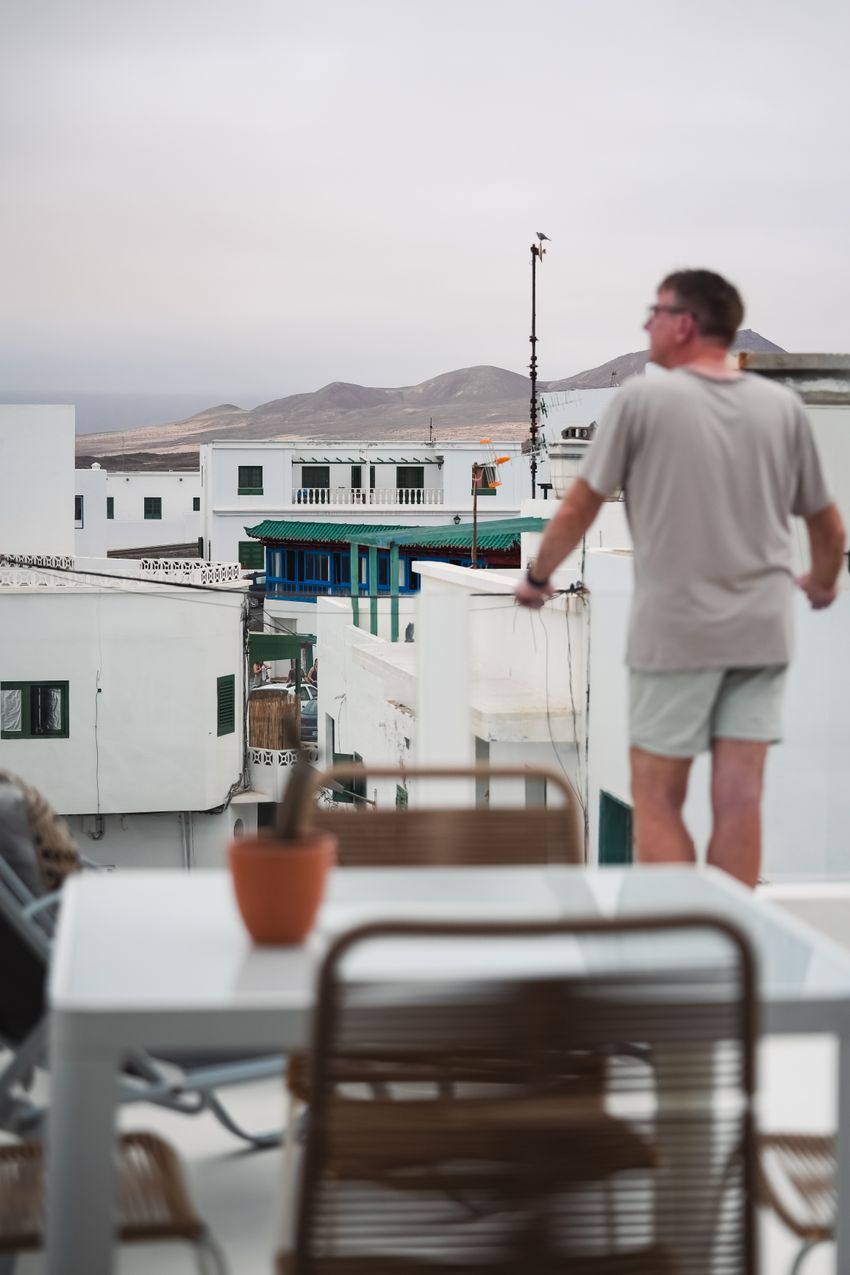 A man gazes over the whitewashed rooftops of Lanzarote, capturing the serene atmosphere of the Canary Islands.
